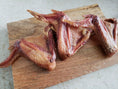 Load image into Gallery viewer, Turkey wings from Naked Beasts on a wooden cutting board, raw, skin-on, reddish-pink.