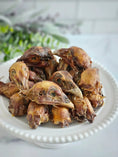 Load image into Gallery viewer, Pheasant heads by Naked Beasts on a white plate; dried brown birds, multiple pieces