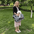 Bild in Galerie-Betrachter laden, Mr. Peanut's Gold Series Expandable V3.0 Pet Carrier, gray with mesh panels, air-travel approved, carried by a woman with a fluffy white dog.