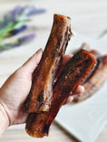 Load image into Gallery viewer, Beef pizzle sticks, dried brown; several short sticks held in hand