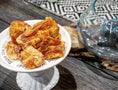 Carica l'immagine nel visualizzatore della galleria, Salmon Fillet chunks from Naked Beasts in a white pedestal dish on a rustic wooden table, orange-brown.