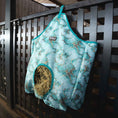 Bild in Galerie-Betrachter laden, Jeffers Expressions top-loading hay bag in turquoise marble pattern, 600 denier; hay peeks from the opening.