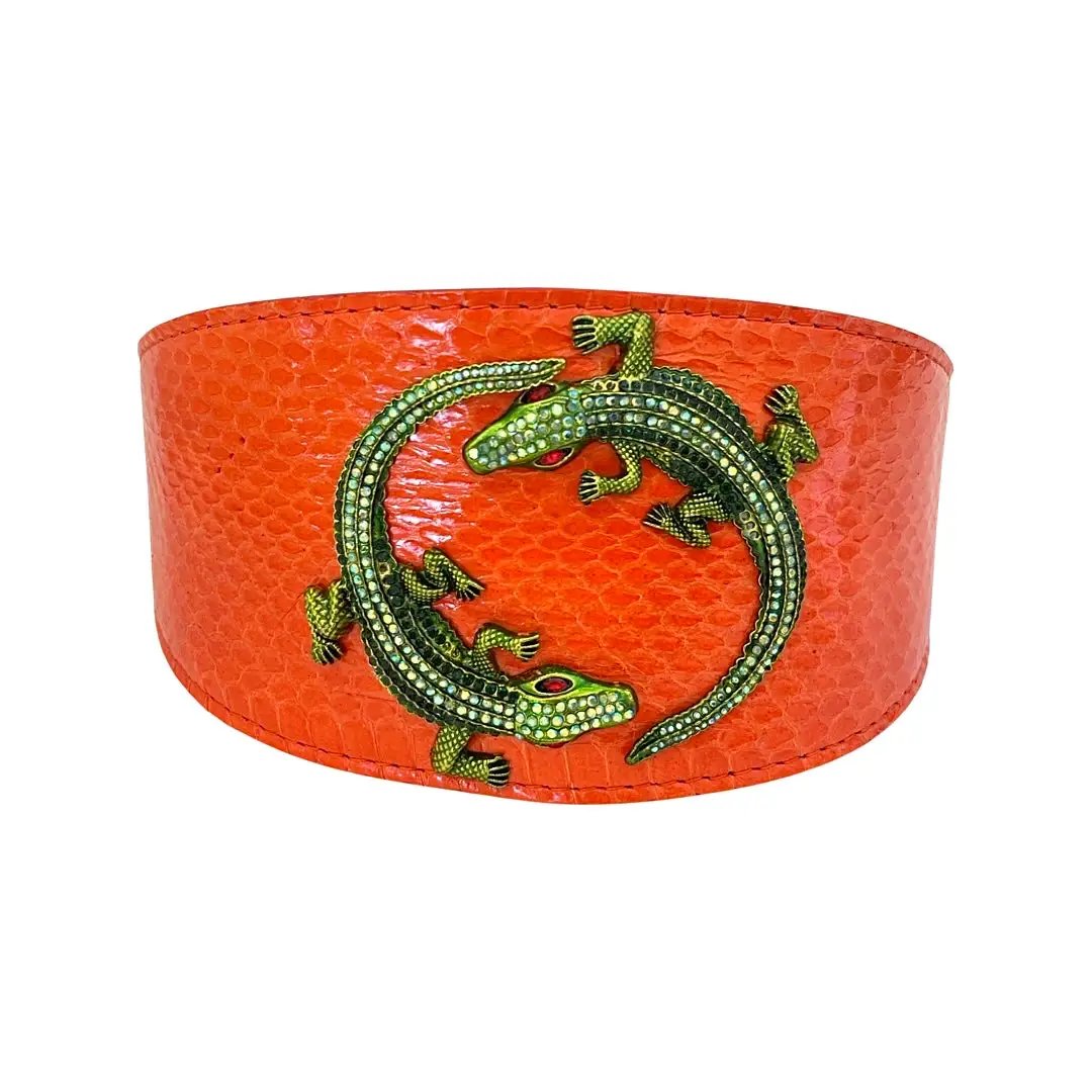 Orange textured leather cuff bracelet with green rhinestone alligator motif.