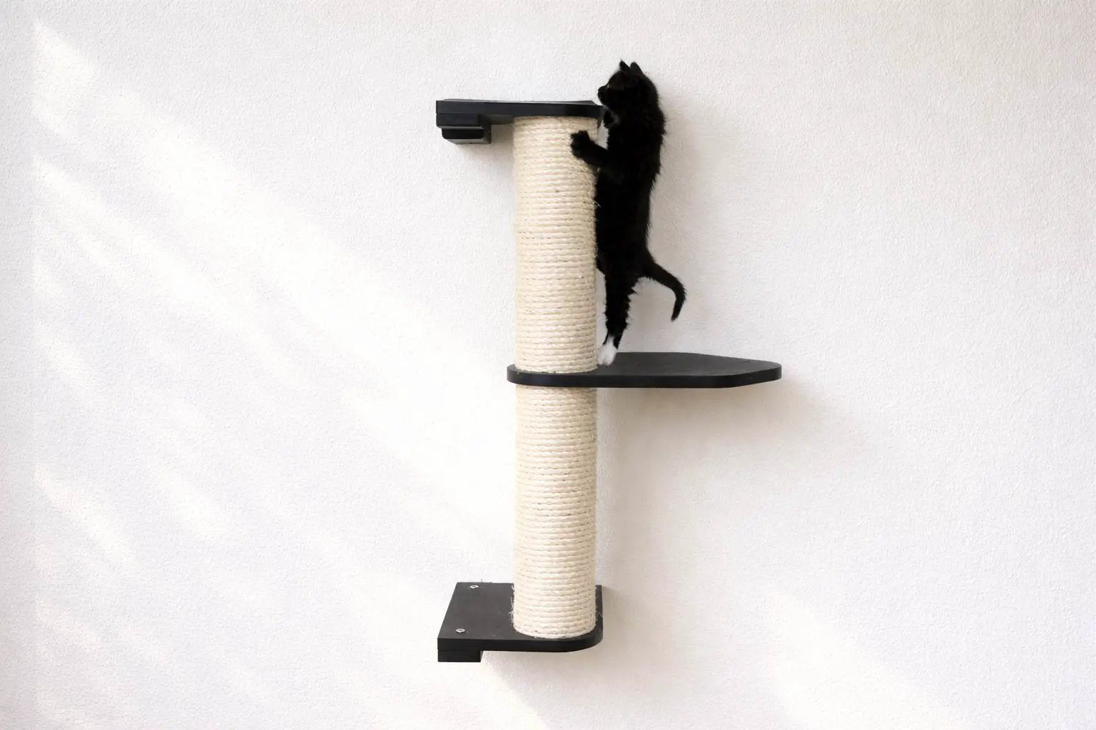 Wall-mounted cat scratching post with beige sisal-wrapped pole and black platforms by Catastrophic Creations