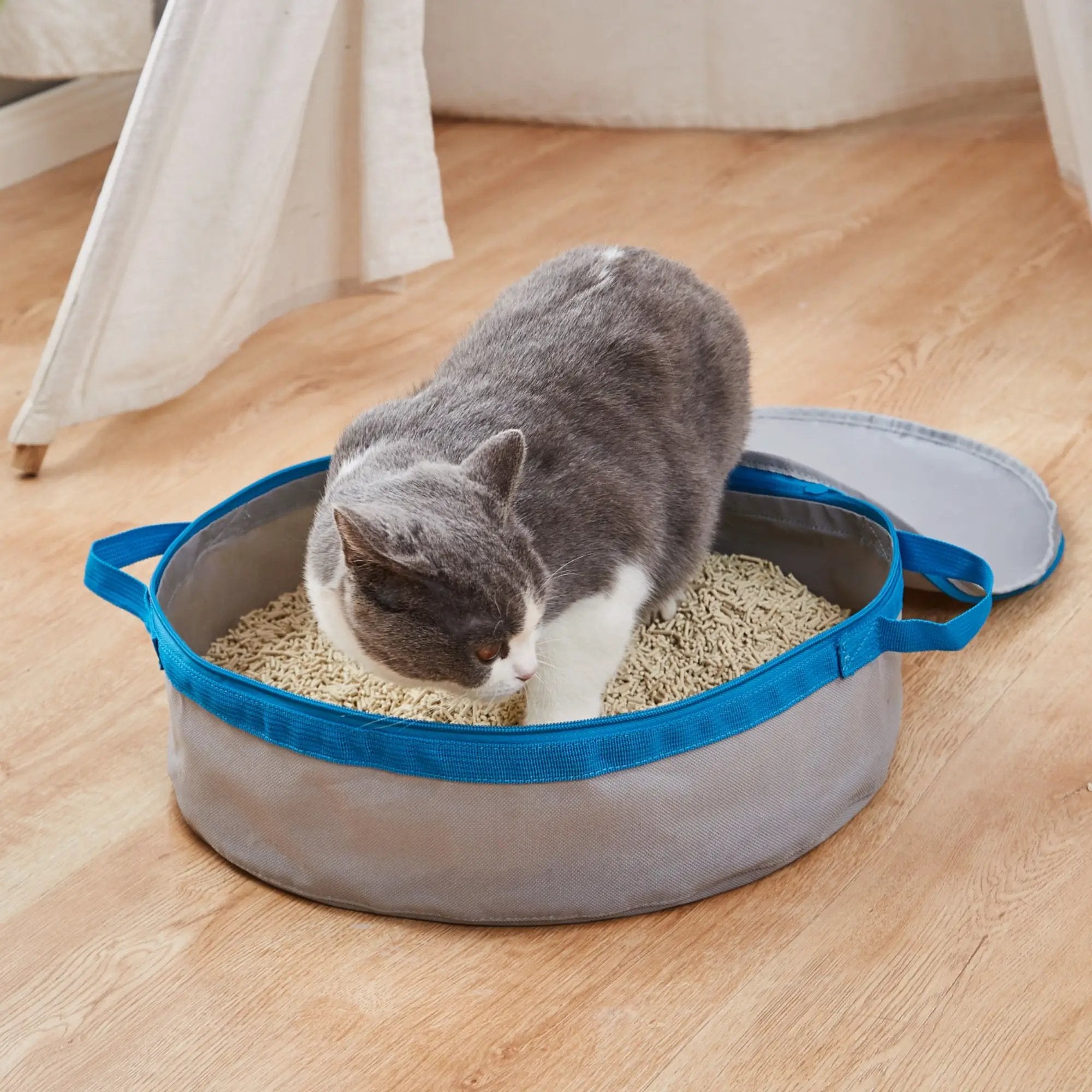 Mr. Peanut's PortaPotty Litter Box for Traveling Kitties, blue fabric portable cat litter box with a gray-and-white cat
