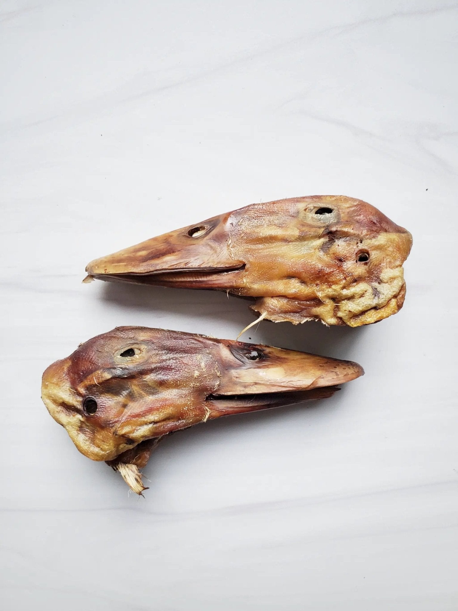 Duck Heads ABF, three dried brown duck heads on a white background