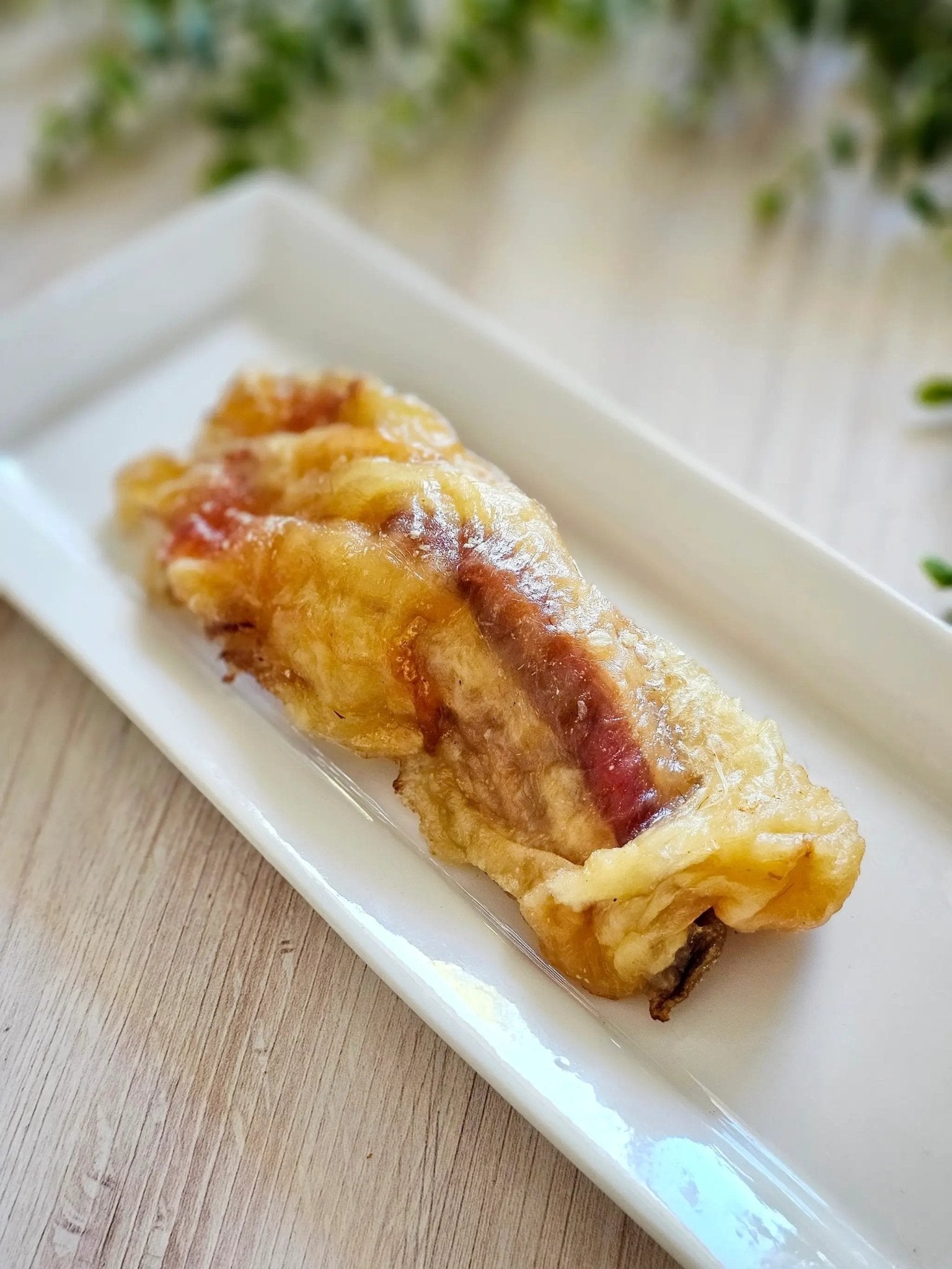 Beef tendon on a white rectangular plate, crispy golden-brown exterior