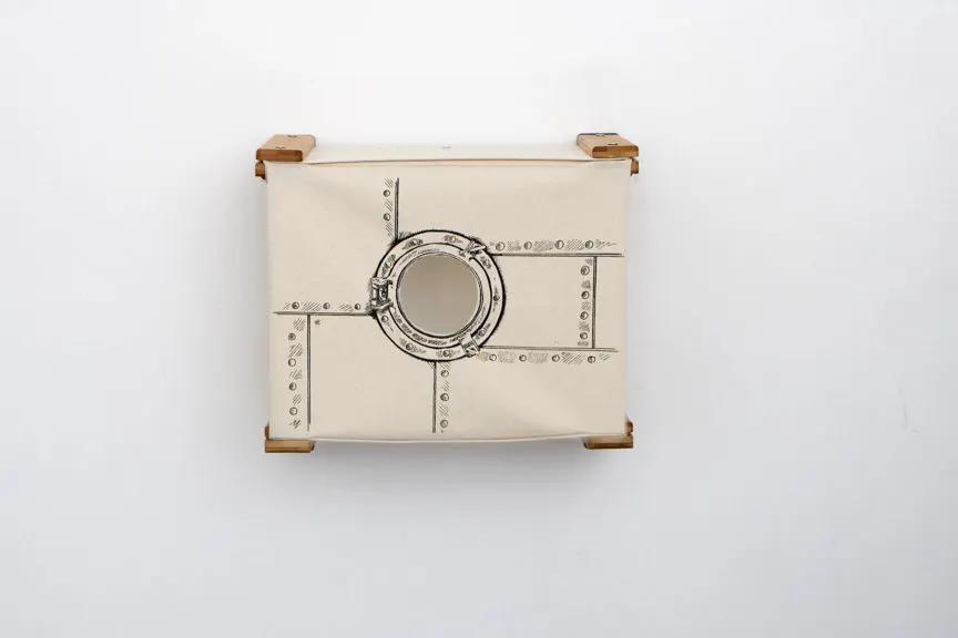 Enclosed cat bed wall cubby by Catastrophic Creations; beige fabric cube with round porthole and wood corners.