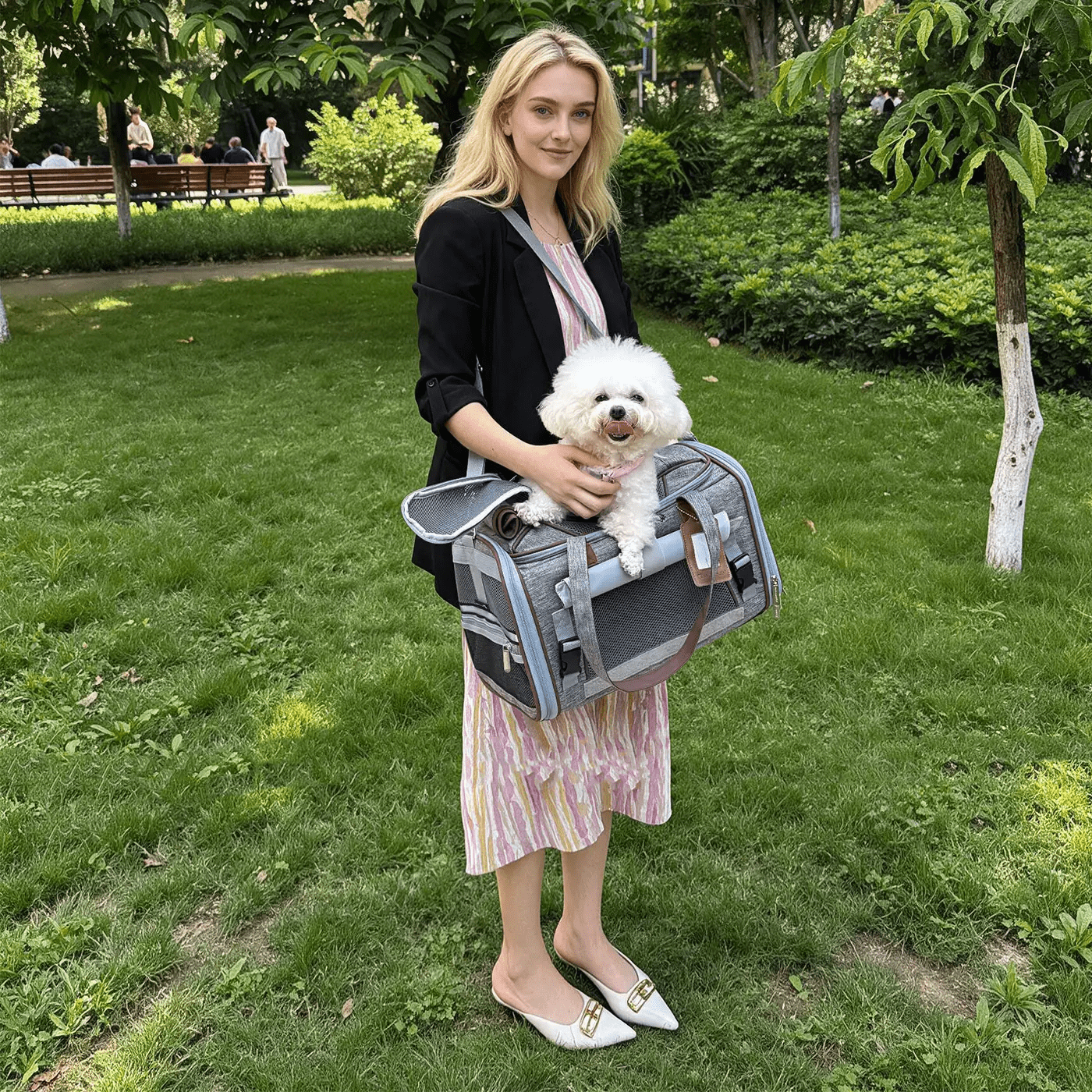 Mr. Peanut's Gold Series Expandable V3.0 Pet Carrier, gray with mesh panels, air-travel approved, carried by a woman with a fluffy white dog.