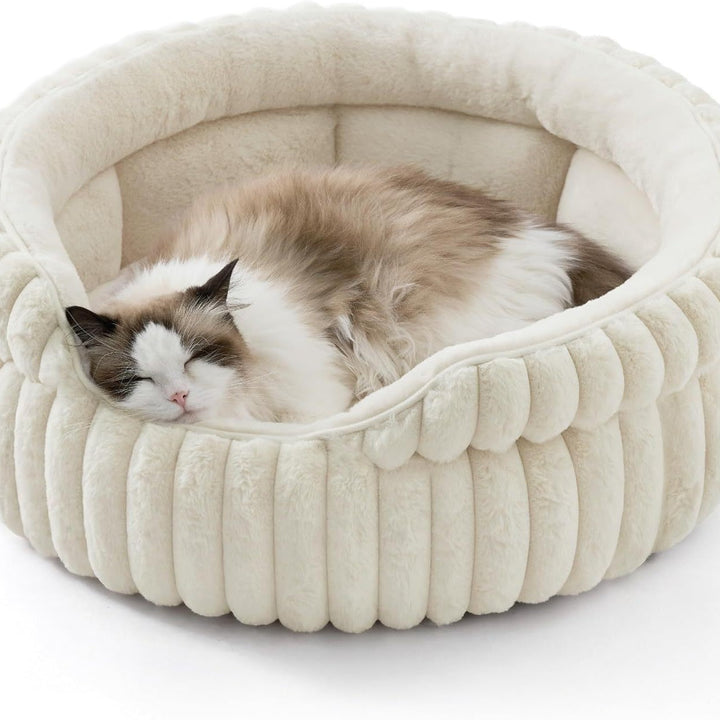 Cat curled inside cream ribbed bolster bed