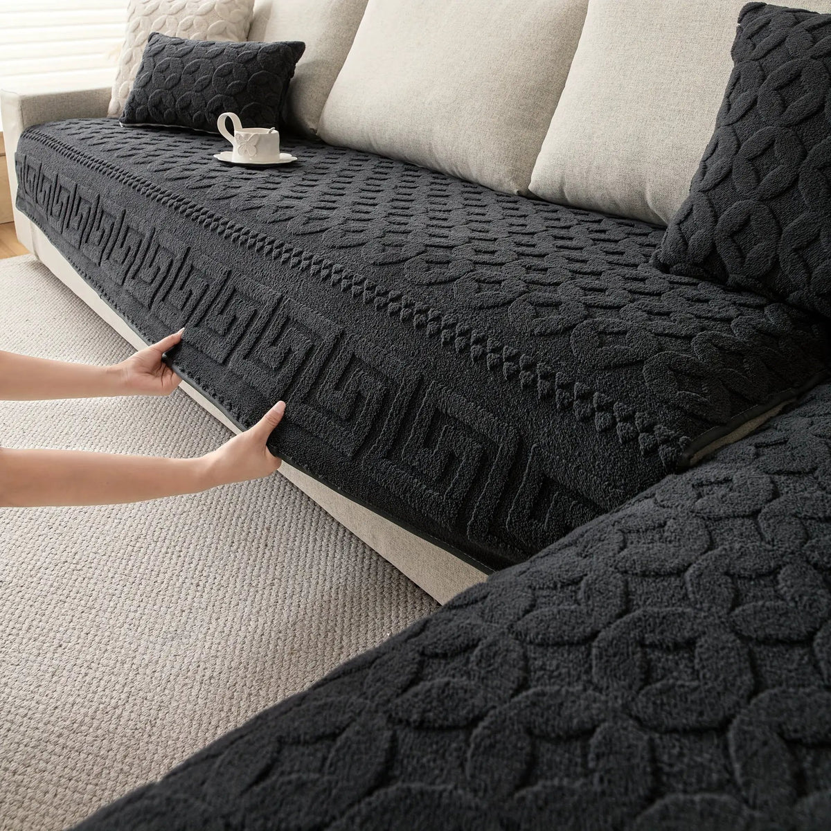 L-shaped couch cover in charcoal gray with chunky knit texture on a beige sofa