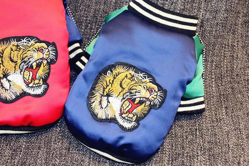 Tiger-head embroidered dog jackets, blue and red with striped cuffs; 2-pack.