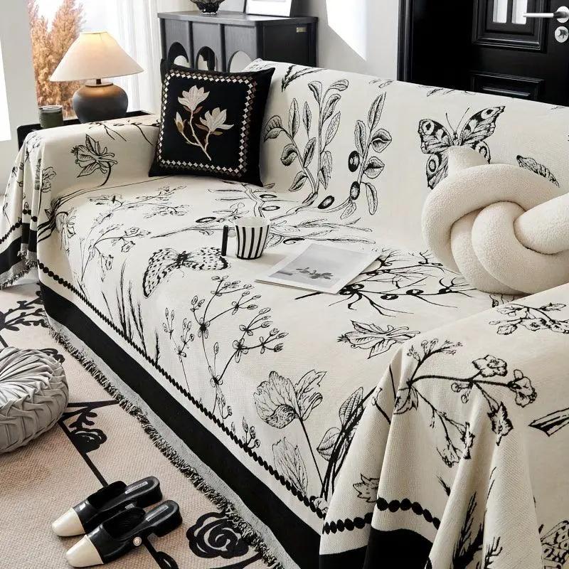Soft & Cozy Chenille Reversible Sofa Cover by topspet in black and white, draped over a floral-print sofa.