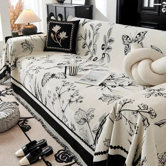 Soft & Cozy Chenille Reversible Sofa Cover by topspet in black and white, draped over a floral-print sofa.