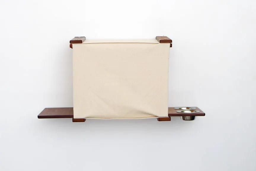 Deluxe Cat Cubby Bed by Catastrophic Creations, beige fabric cat condo with wooden shelves and feeding bowls.