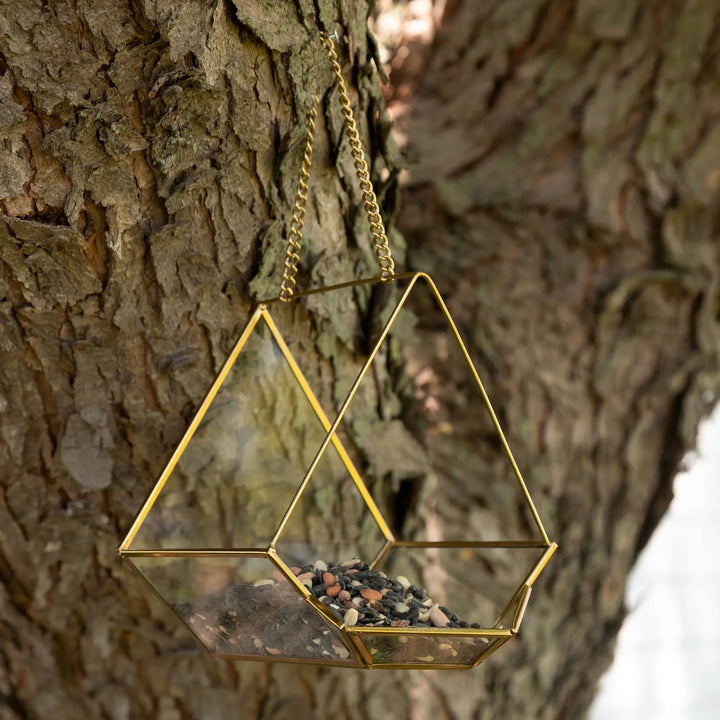 Open Air Glass Bird House by GreaterGood, two gold geometric hanging bird feeders with glass panels and seed.