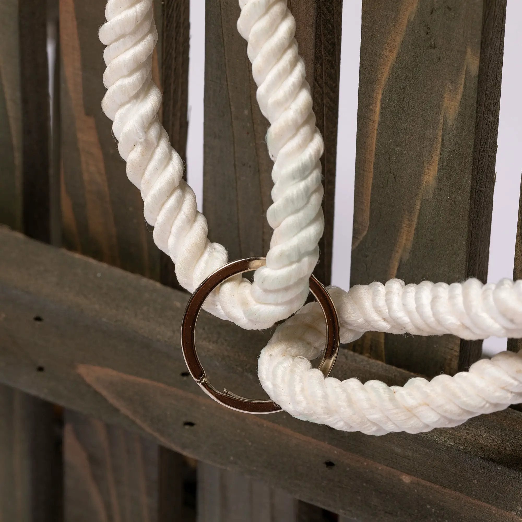Hanging Bench Bird & Squirrel Feeder with white twisted rope and metal ring against brown wood backdrop