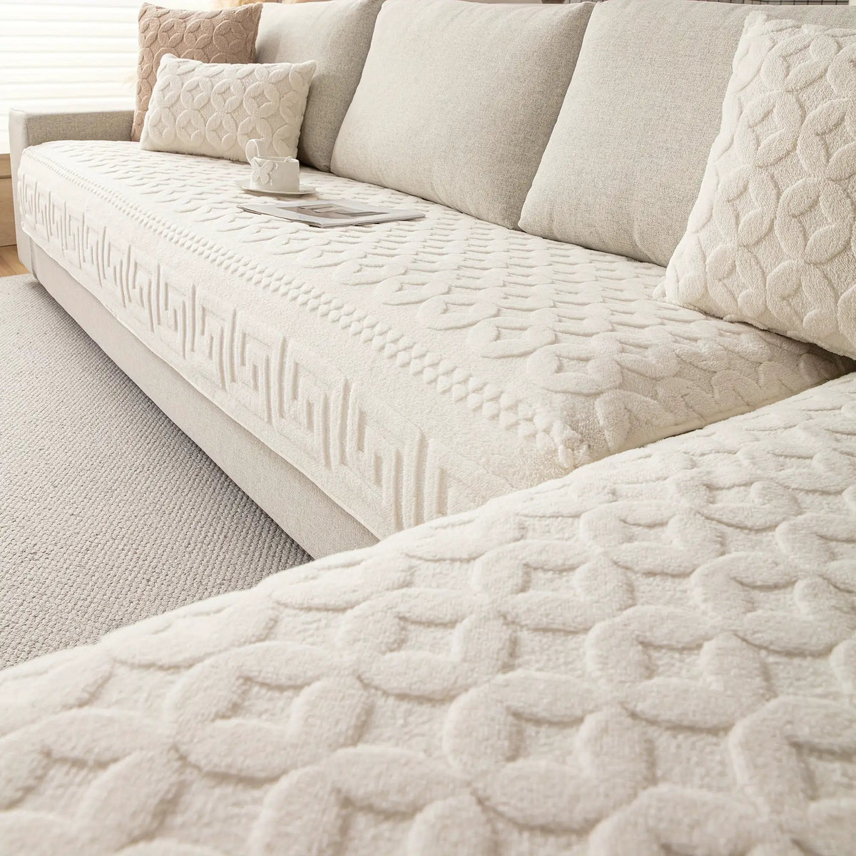 L-shaped cream quilted couch cover on a beige sofa with matching cushions