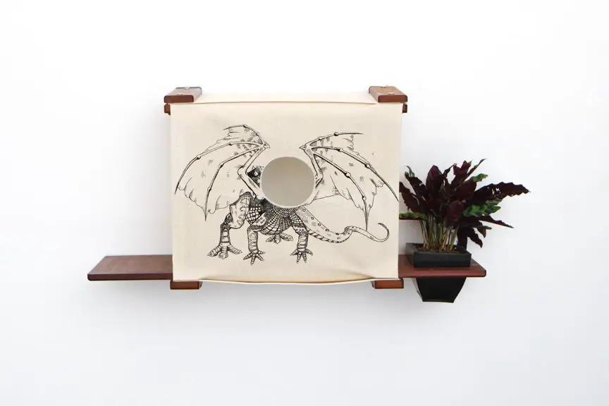 Deluxe Cat Cubby Bed with beige fabric and dragon illustration, mounted on dark wooden shelves.