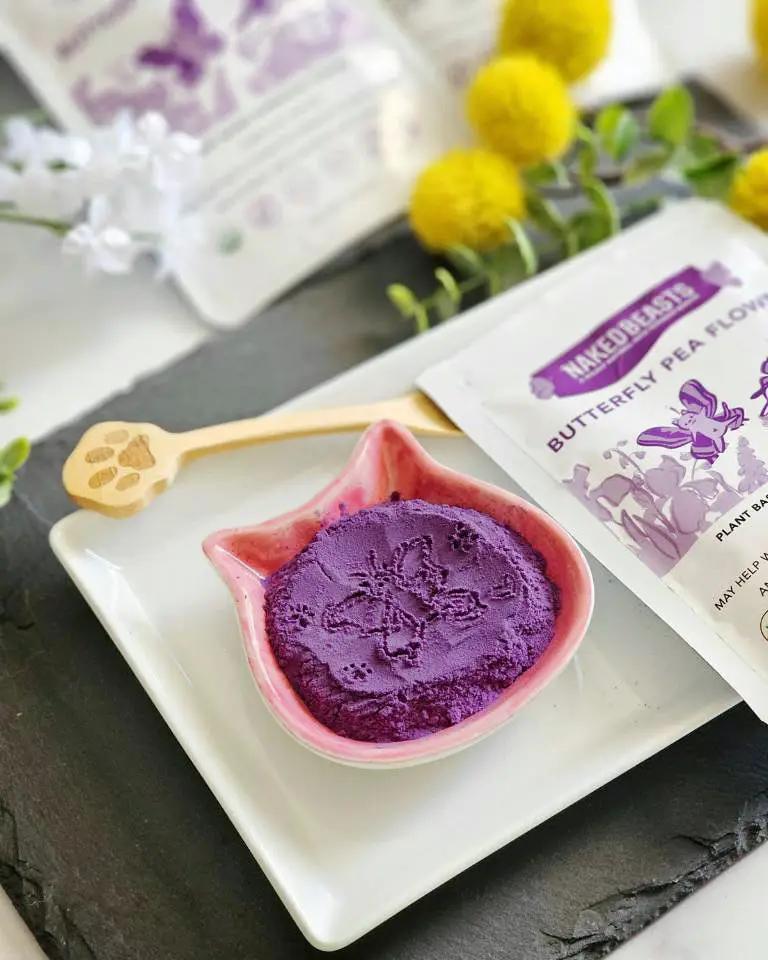 Butterfly pea flower powder by Naked Beasts, organic; purple powder in a pink leaf-shaped bowl with packaging visible.