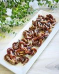 Load image into Gallery viewer, Lamb Pizzle - Limited Edition by Naked Beasts, dried twisted slices on white platter
