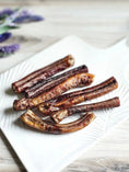 Load image into Gallery viewer, Beef Pizzle sticks, Naked Beasts, six short brown dried jerky sticks on a white plate
