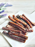 Load image into Gallery viewer, Beef pizzle sticks on a white plate; dried brown-red treats, Limited Edition by Naked Beasts
