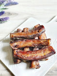 Load image into Gallery viewer, Naked Beasts beef pizzle sticks, short dried brown chews on a white plate; multiple pieces, limited edition
