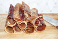 Load image into Gallery viewer, Naked Beasts Beef Trachea chews, grass-fed & finished, stacked rolled tubes on board (multiple pieces)
