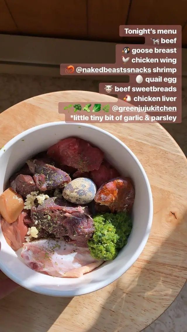 Shrimp in a white bowl with assorted raw meats, garlic and parsley, Naked Beasts