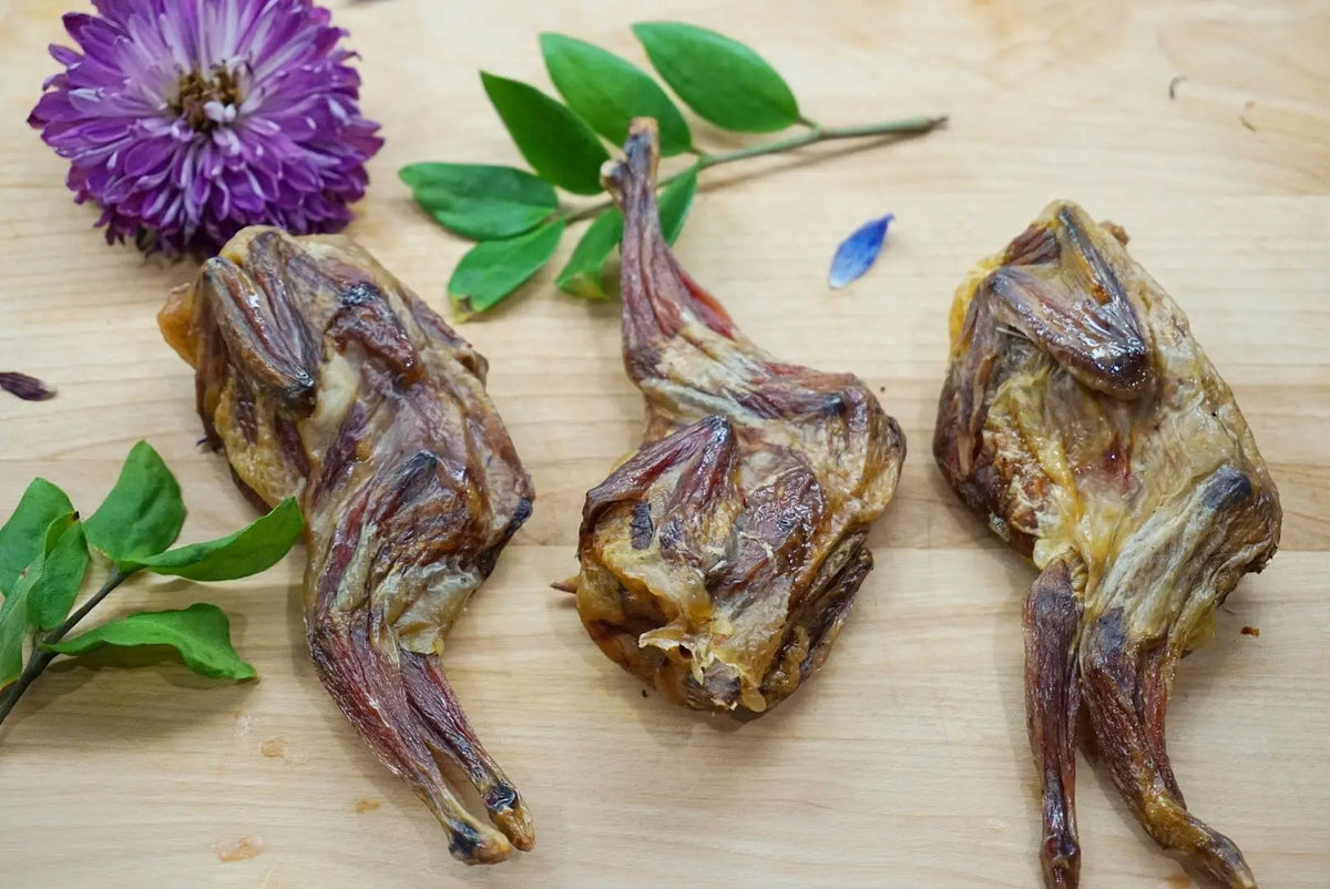 Whole quails (bone-in) by Naked Beasts, three roasted quails on a wooden board.