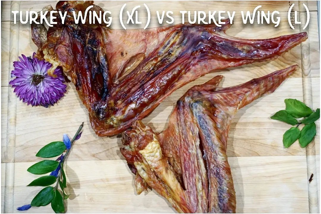 Turkey wings (XL and L) on a wooden cutting board with a purple flower and green sprigs