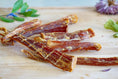 Load image into Gallery viewer, Mahi Mahi jerky strips by Naked Beasts, wild-caught, on a wooden board
