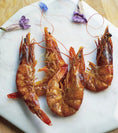 Load image into Gallery viewer, Shrimp by Naked Beasts; four orange-red cooked prawns on a marble board
