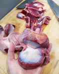 Load image into Gallery viewer, Turkey gizzards (ABF), thin-cut, raw pieces on a wooden cutting board
