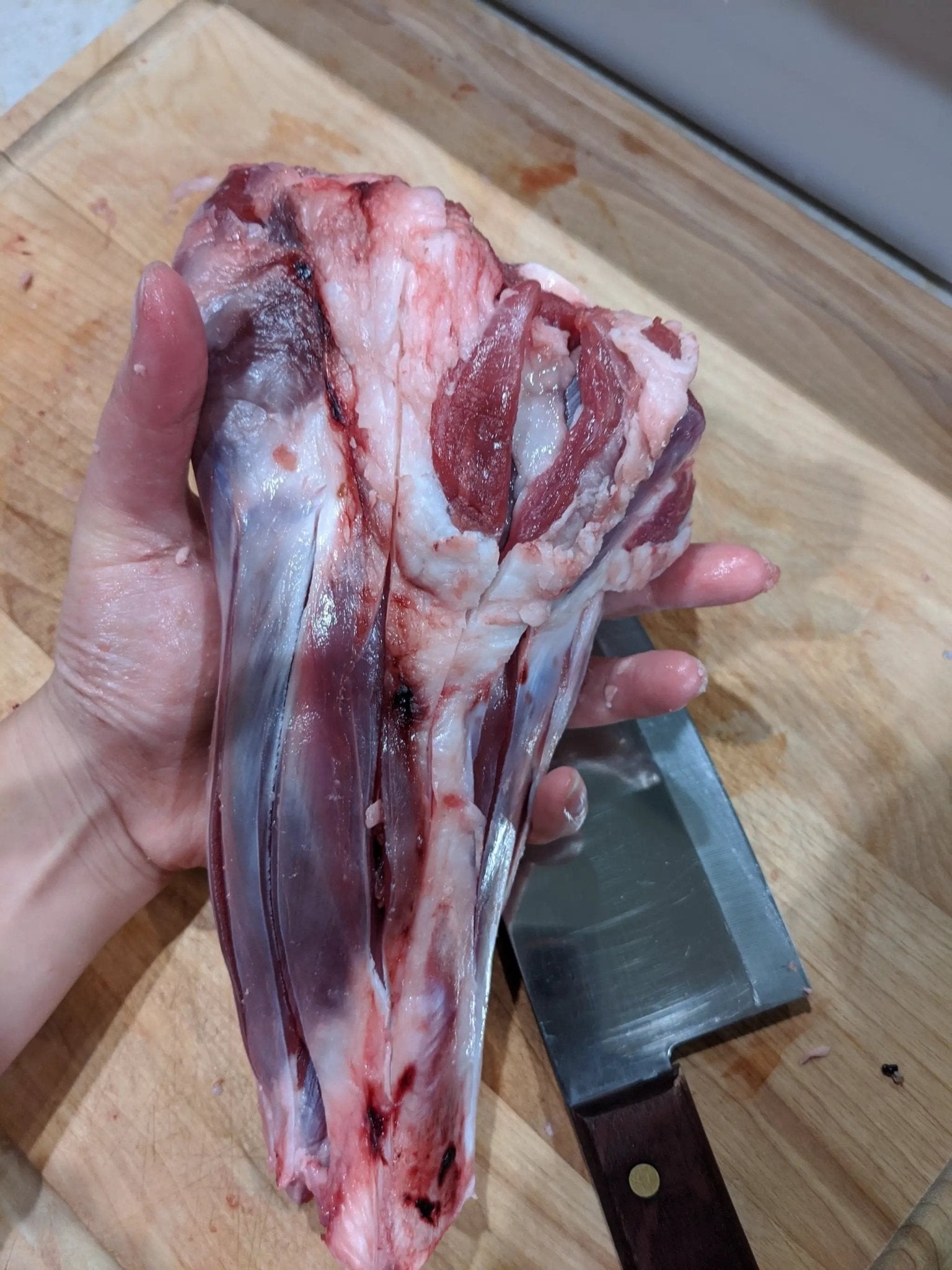 Two lamb shanks from Naked Beasts, pasture-raised, bone-in cuts on a wooden cutting board