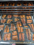 Carica l'immagine nel visualizzatore della galleria, Salmon fillet slices on metal smoking racks; orange-brown smoked pieces, Naked Beasts
