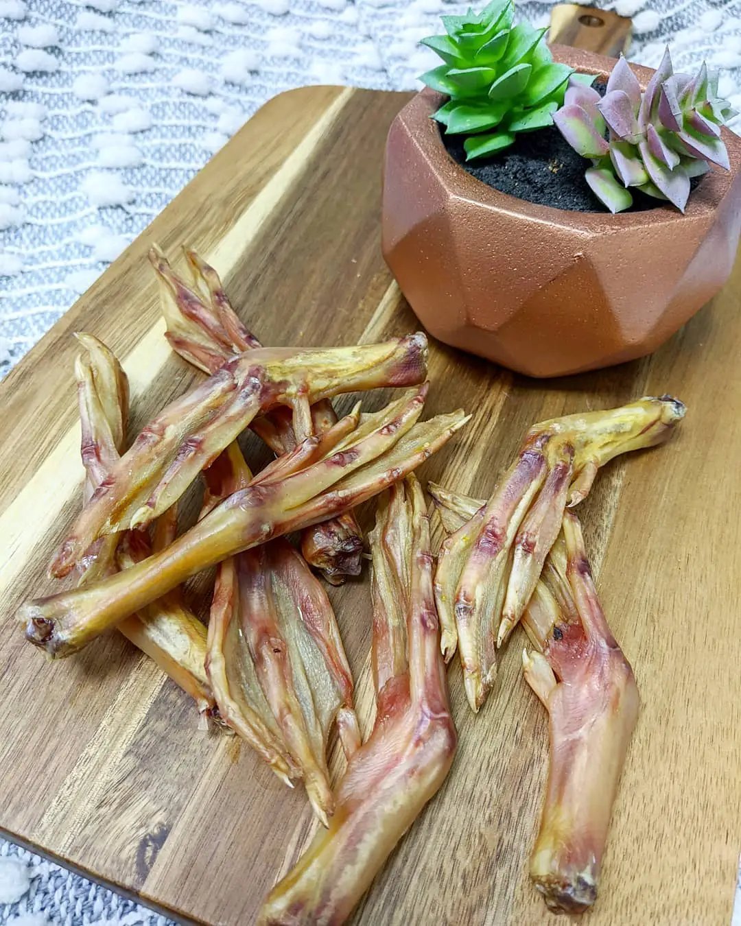 Duck feet (ABF) by Naked Beasts; dried beige-brown pieces on a wooden board