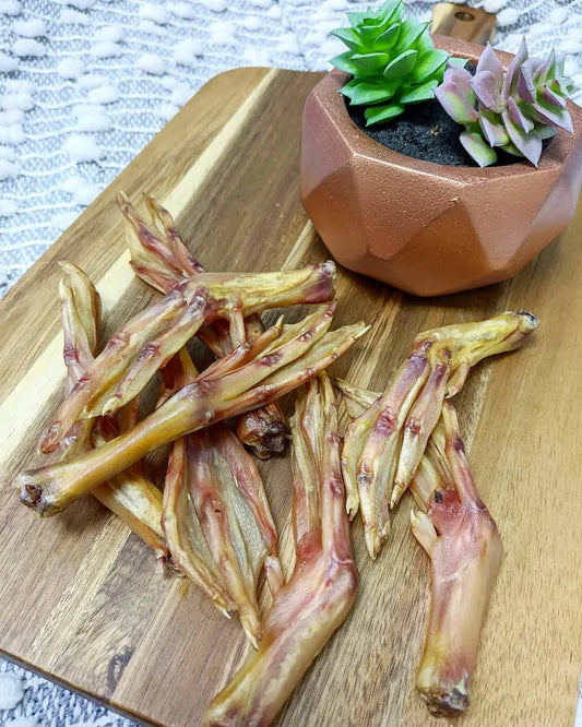 Duck feet (ABF) by Naked Beasts; dried beige-brown pieces on a wooden board