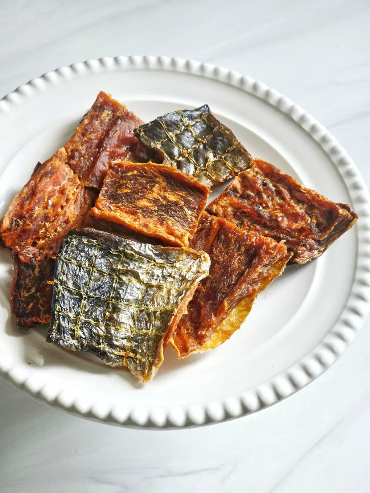 Salmon fillet pieces with skin on on a white plate, Naked Beasts