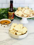Carica l'immagine nel visualizzatore della galleria, Sweet potato chips by Naked Beasts in a bowl on a marble countertop, with dip and beer bottle in background.
