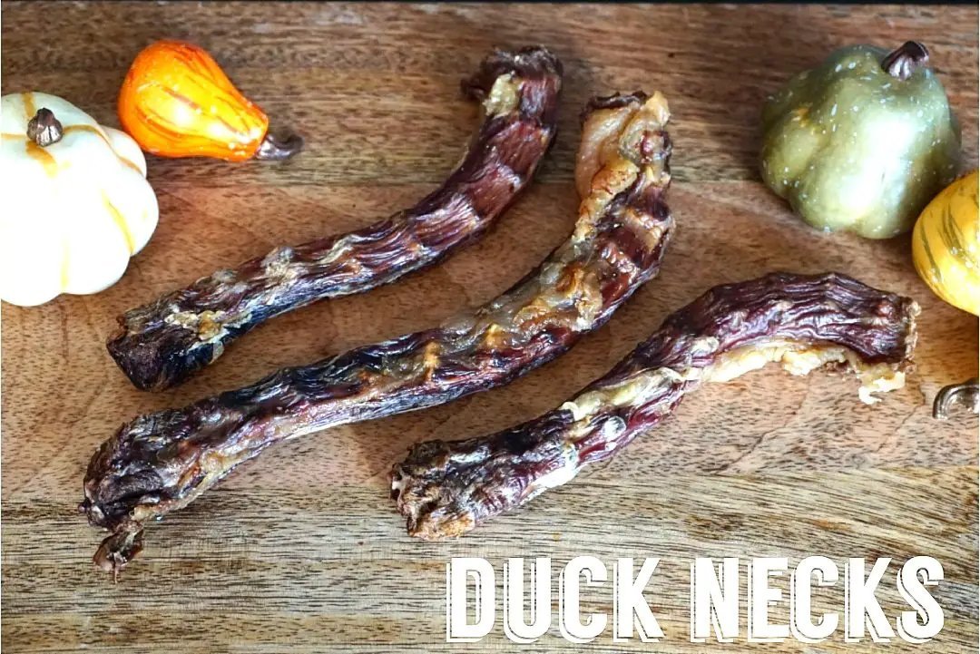Duck Necks by Naked Beasts on a wooden board with small gourds; three pieces.