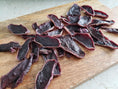 Load image into Gallery viewer, Beef tongue thin-cut slices by Naked Beasts on a wooden cutting board; dark red with pink edges
