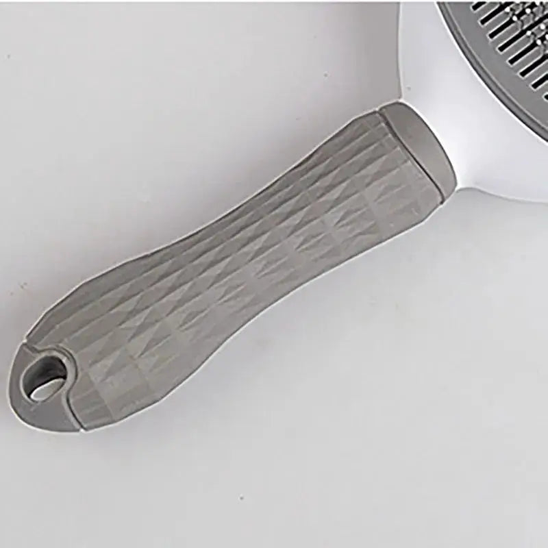 Deshedding grooming brush for dogs and cats with a gray textured handle