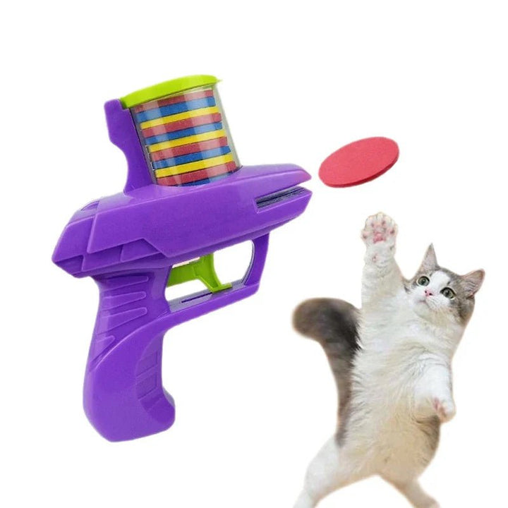 Purple foam disc launcher beside playing cat