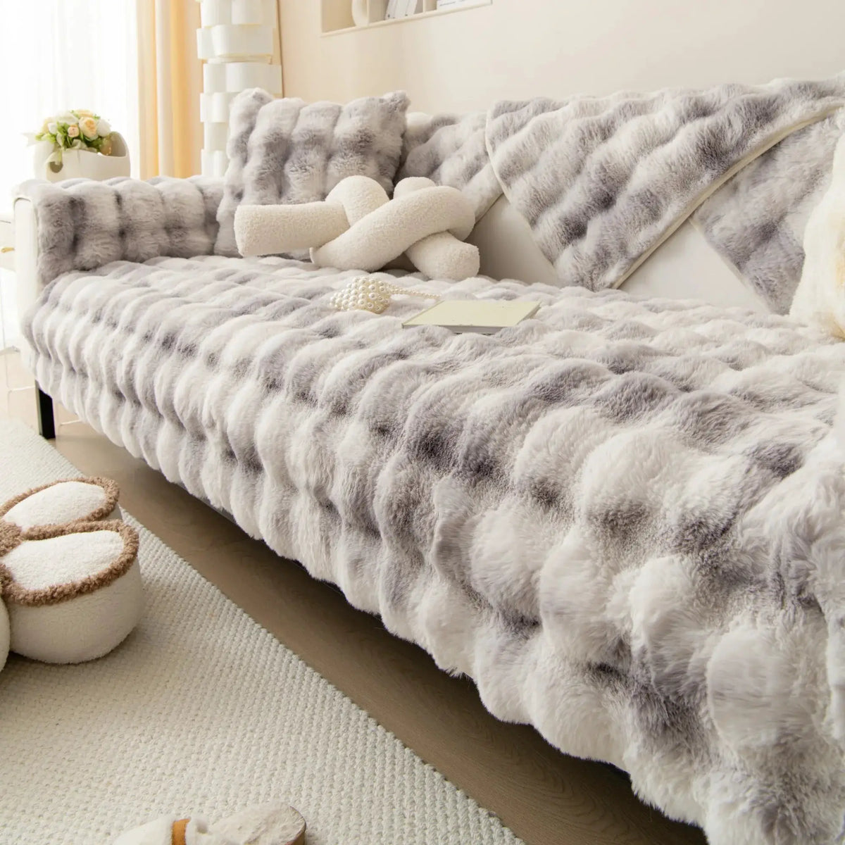 Velvet couch cover in soft gray plush fur with matching throw cushions on sofa