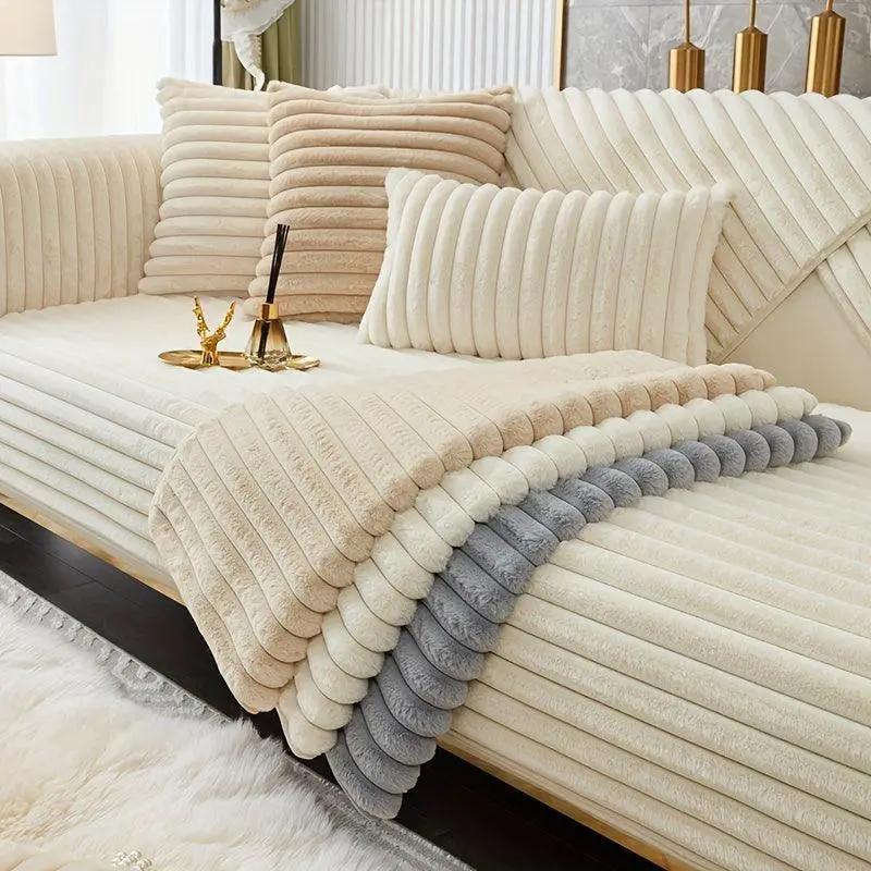 Luxurious rabbit fur sofa slipcover in light grey and cream tones.