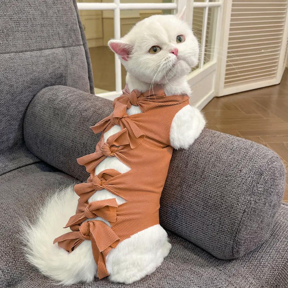 Lace-up cat recovery clothing in orange-brown polyester with multiple side bows for post-op healing