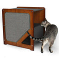 Load image into Gallery viewer, The Grotto cat condo in brown wood with a grey fabric scratching panel; cat beside it.
