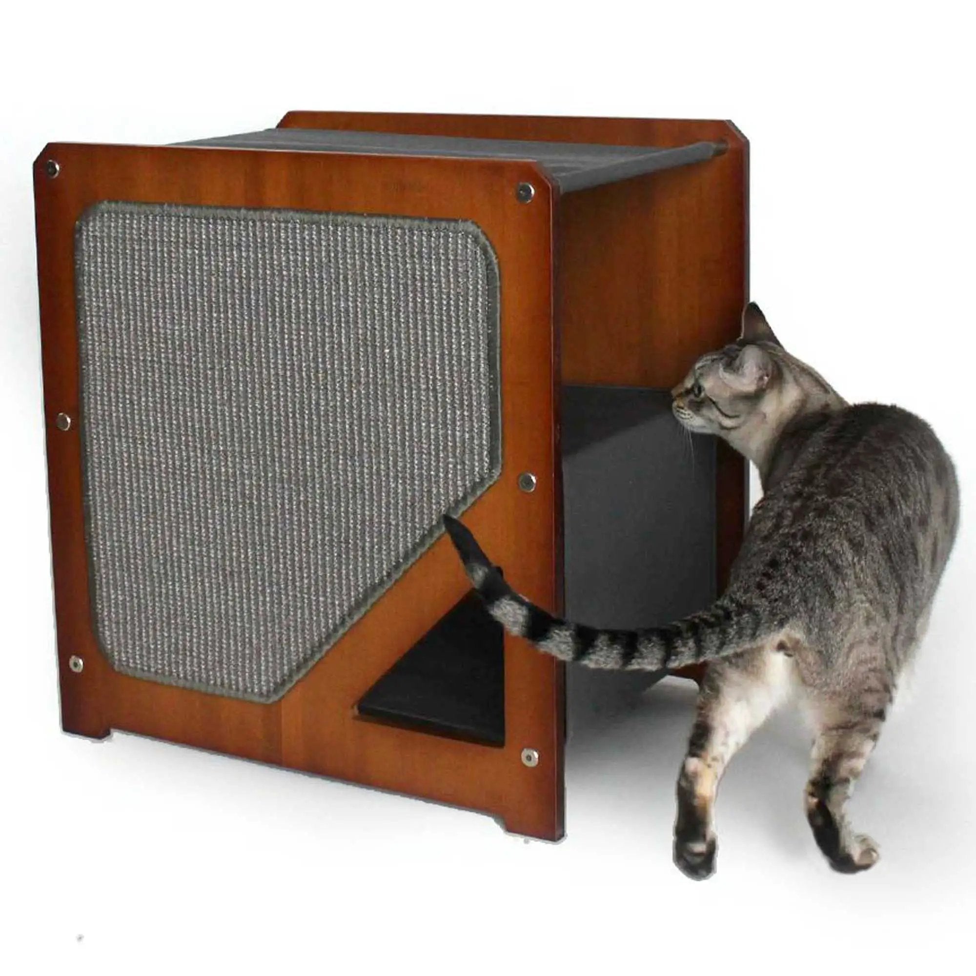 The Grotto cat condo in brown wood with a grey fabric scratching panel; cat beside it.